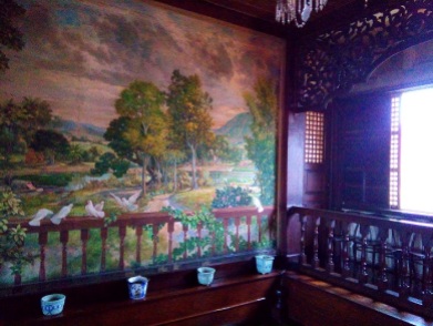 The mural of a Philippine idyllic scene featuring nipa huts and cascos or covered boats